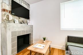 Miami apartment for rent - A living room with a fireplace and a flat screen TV mounted above it.