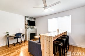 Miami apartment for rent - A room with a wooden table and chairs, a fireplace, and a ceiling fan.