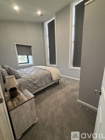 Emmetsburg apartment for rent - A living room with a grey carpet and a black couch.
