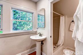 Portland house for rent - A bathroom with a white sink and a window with trees visible outside.