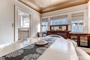 Portland house for rent - A bedroom with a large bed and a chandelier.