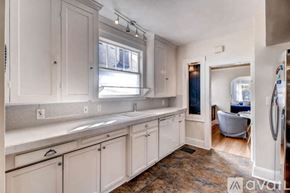 Portland house for rent - A kitchen with white cabinets and a window above the sink.