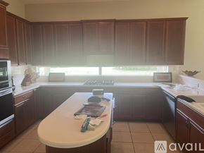 Fort Myers house for rent - A kitchen with brown cabinets and a white countertop.