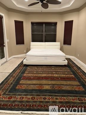 Fort Myers house for rent - A bedroom with a large bed and a rug on the floor.