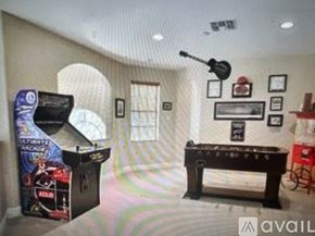 Fort Myers house for rent - A room with a pool table, a pinball machine, and a jukebox.