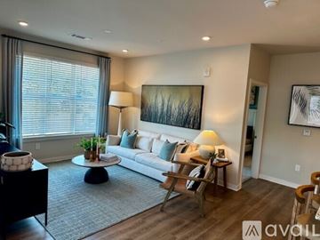 San Antonio apartment for rent - A living room with a white couch, a coffee table, and a painting on the wall.