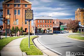 Altoona apartment for rent - A street view with a signpost in the foreground and a building with a clock tower in the background.
