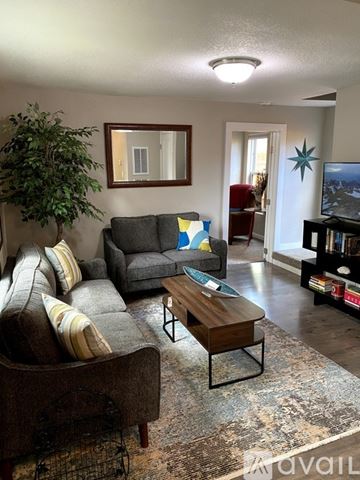 Colorado Springs house for rent - A living room with a grey couch and a brown chair.