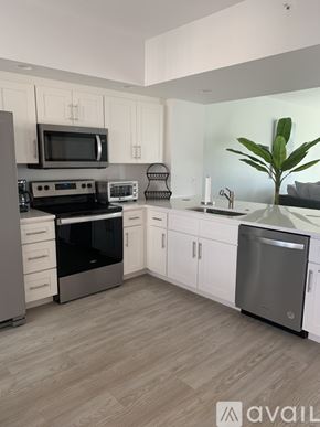 Largo condo for rent - A kitchen with a wooden floor and white cabinets.