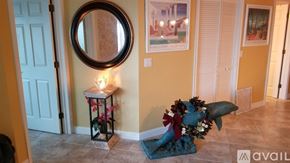Vero Beach condo for rent - A candlelit lantern with flowers sits on a tiled floor next to a blue cushion.