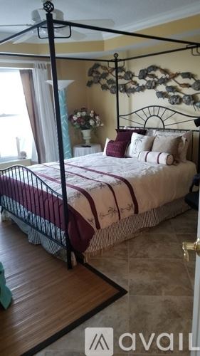 Vero Beach condo for rent - A bedroom with a four poster bed and a window.