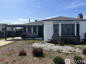 Los Angeles house for rent - A white house with a black gate and a brick chimney.