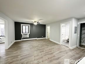Chicago apartment for rent - A spacious room with a ceiling fan and a window.