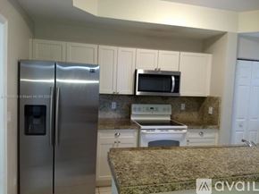 Royal Palm Beach townhouse for rent - A kitchen with a granite countertop and stainless steel appliances.