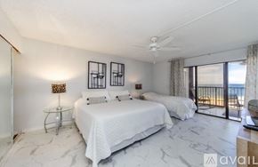 Clearwater condo for rent - A bedroom with two beds and a balcony overlooking the ocean.