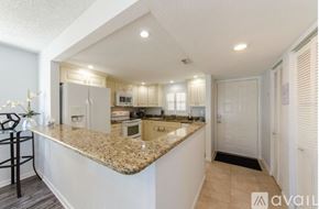 Clearwater condo for rent - A kitchen with granite countertops and white cabinets.
