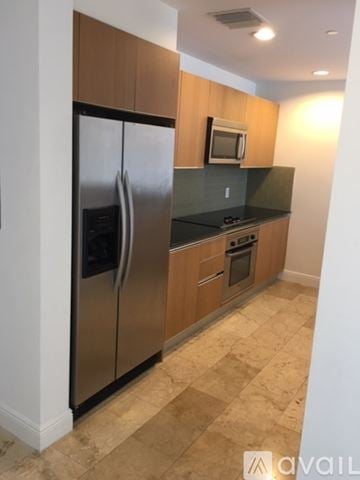 Miami apartment for rent - A kitchen with a refrigerator, microwave, oven and countertop.