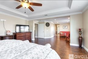 Corona apartment for rent - A bedroom with a large bed and a ceiling fan.