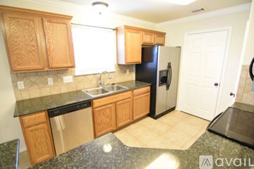 Temple apartment for rent - A kitchen with wooden cabinets and black appliances.
