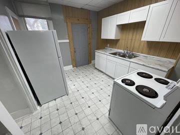 Terre Haute apartment for rent - A kitchen with a white fridge, white cabinets, and a white stove top oven.