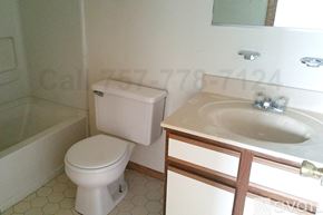 Norfolk apartment for rent - A white toilet sits next to a sink in a bathroom.