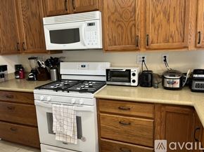 Lompoc apartment for rent - A kitchen with a white stove and wooden cabinets.