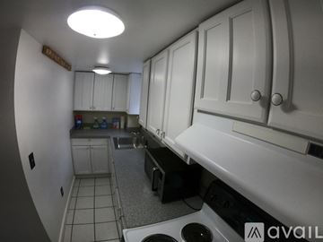Laconia apartment for rent - A kitchen with white cabinets and a black dishwasher.