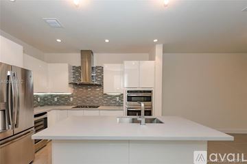 Doral apartment for rent - A modern kitchen with a white countertop and stainless steel appliances.