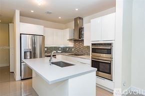 Doral apartment for rent - A modern kitchen with a white countertop and stainless steel appliances.