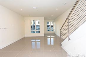 Doral apartment for rent - A spacious room with a staircase on the right and a window with a view of a building in the distance.