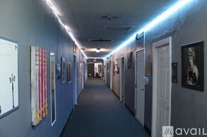 Los Angeles apartment for rent - A long hallway with doors on both sides and pictures on the wall.