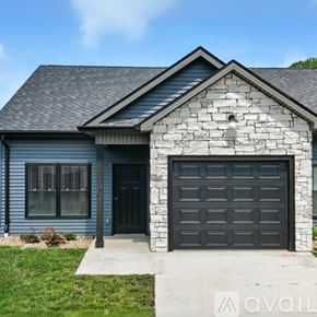 Jonesborough apartment for rent - A house with a grey garage door and a stone facade.
