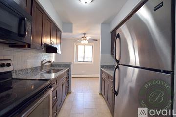 Chicago apartment for rent - A kitchen with a stainless steel refrigerator and a granite countertop.