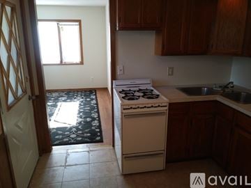 Minneapolis apartment for rent - A kitchen with a white stove and wooden cabinets.