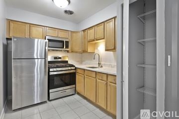 Chicago apartment for rent - A kitchen with wooden cabinets and stainless steel appliances.