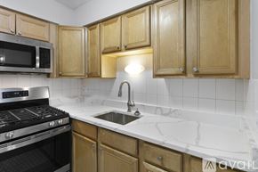 Chicago apartment for rent - A kitchen with wooden cabinets and a black stove top oven.