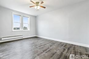 Chicago apartment for rent - A room with a ceiling fan and a window overlooking a cityscape.