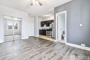 Chicago apartment for rent - A spacious living room with a kitchen area in the background.