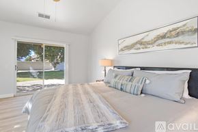 La Quinta house for rent - A bedroom with a large bed and a painting on the wall.