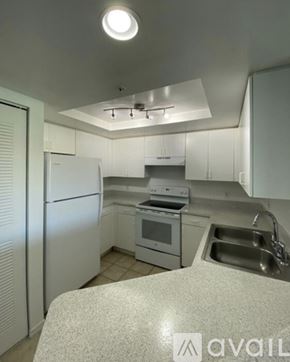 West Palm Beach condo for rent - A kitchen with white appliances and cabinets.