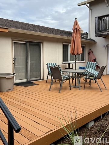 Marina apartment for rent - A living room with a couch, a painting of a beach scene, and a wooden coffee table.