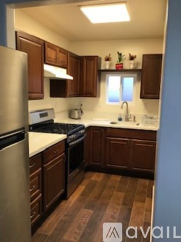 Chula Vista house for rent - A kitchen with wooden cabinets and a stainless steel refrigerator.