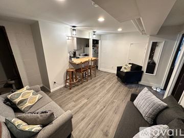 Bloomington apartment for rent - A living room with a grey couch and a wooden floor.