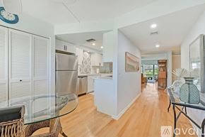 Naples condo for rent - A modern kitchen with a glass table and a wicker chair.