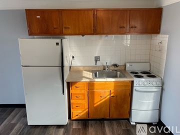 Cincinnati apartment for rent - A kitchen with wooden cabinets and a white fridge.