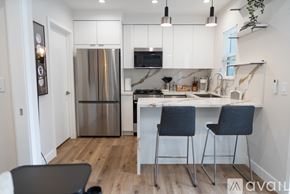 North Hollywood apartment for rent - A kitchen with a refrigerator, stove, and two chairs.