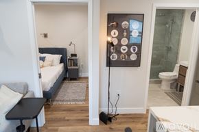 North Hollywood apartment for rent - A modern bedroom with a bed, nightstand, and a wall-mounted control panel.