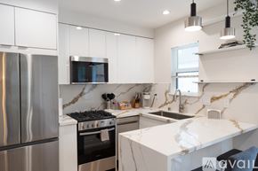 North Hollywood apartment for rent - A modern kitchen with a stainless steel refrigerator and a white marble countertop.