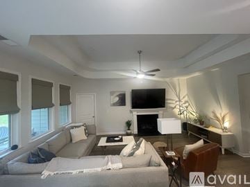 Boiling Springs house for rent - A living room with a grey couch and a television on the wall.