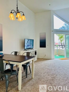 Huntington Beach condo for rent - A dining room with a table and chairs and a television.